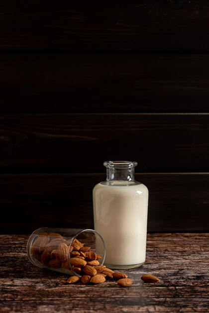 健活方式杏仁牛奶装在一个瓶子里 在深色复古木背景上 有复制空间健康饮食坚果素食者