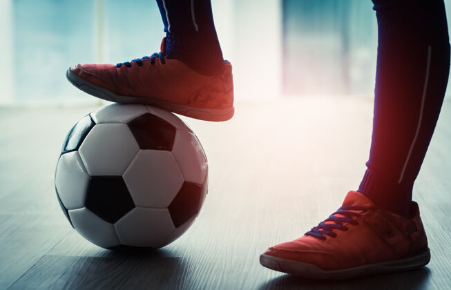 运动足球孩子的脚踏上了青少年室内运动的足球年轻人足球比赛