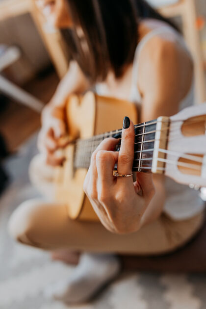举行年轻女子弹白吉他戴着白色耳机听音乐的女人学习可爱休闲