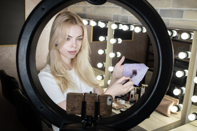 粉一位年轻女子站在一盏彩灯前 在网上开设化妆课程女性博客配饰