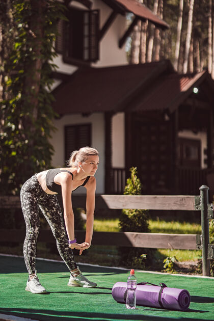 伸展运动在后院练习晨练瑜伽和伸展的女人健康的生活方式运动冥想宁静