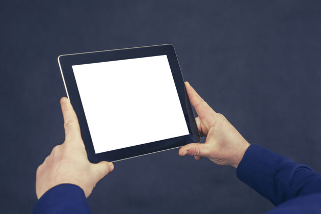 智能穿着蓝色夹克的商人手里拿着一个白色屏幕的平板电脑模型技术手机空白