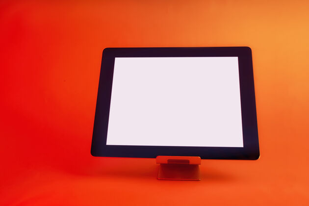 教育白屏平板电脑在明亮的红色创意灯的映衬下明亮设备电子