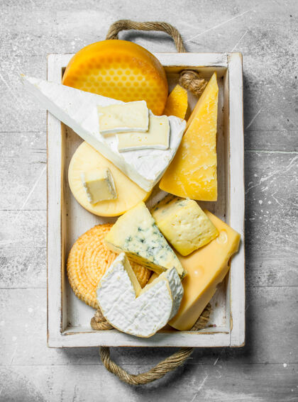 切片不同种类的奶酪放在木制托盘里熟食奶酪开胃菜