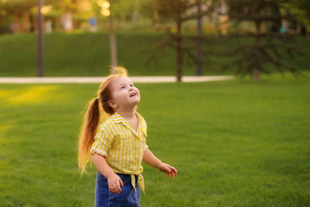 童年快乐的4-5岁小女孩在公园里玩肥皂泡孩子们的生活方式草可爱户外