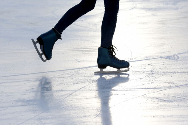 距离阳光下溜冰场上的人雪脚冰