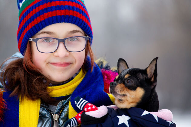 美丽冬日少女的画像在她的温暖服装.青少年穿蓝色衣服的女孩吉娃娃帽和女孩在一起人帽子可爱