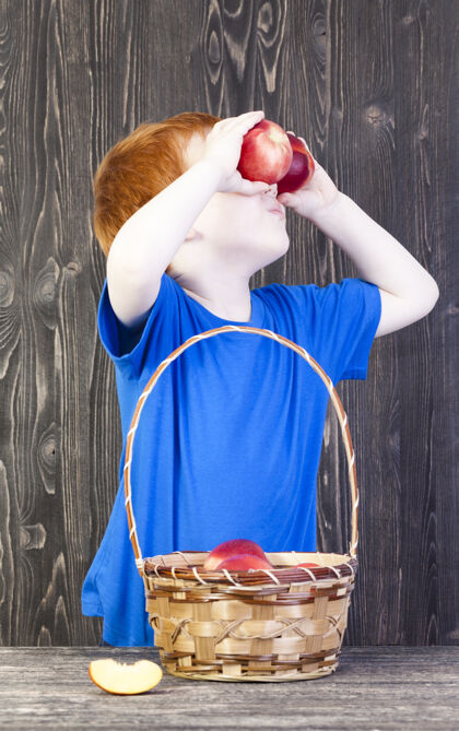 美味一个欧洲男孩在玩他放在眼前的成熟油桃 特写镜头食物健康孩子