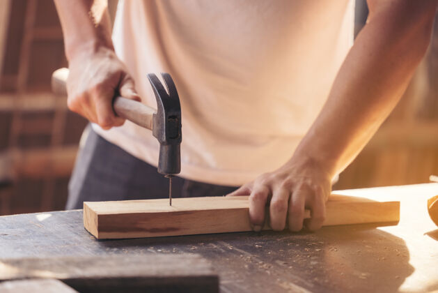 制造一个年轻的男木匠在车间里用铣床做一根木棒 人严重技能