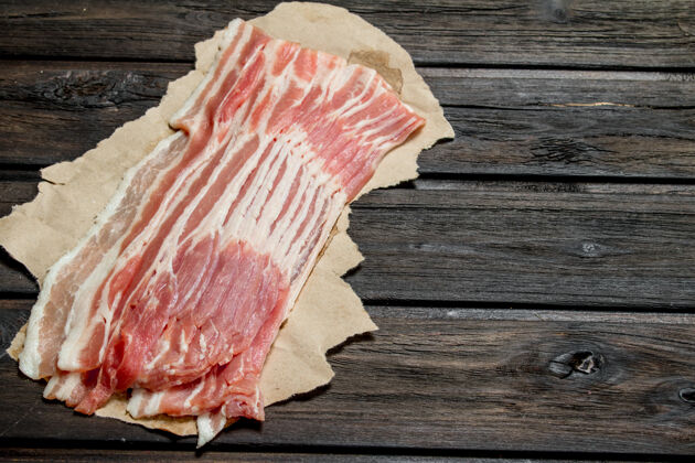 猪肉生培根纸上一个木制的表面咸的烹饪生的