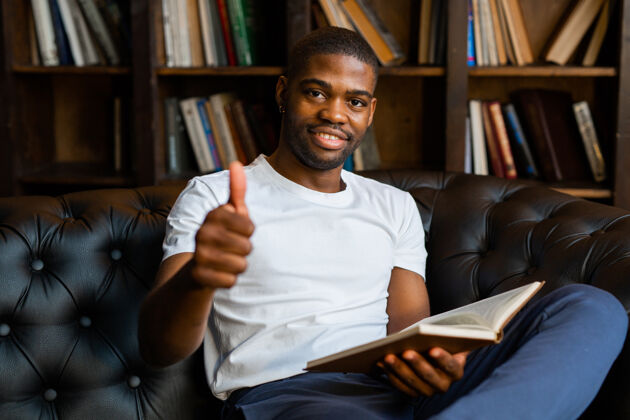 书籍英俊的非洲小伙子用手势看书休闲阅读家伙