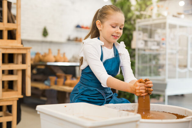 工艺漂亮的小女孩在陶艺作坊里做陶罐手工壶高加索