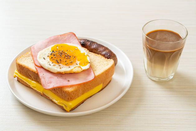 肉自制面包烤奶酪火腿煎蛋配猪肉香肠和咖啡当早餐橙子传统蛋黄