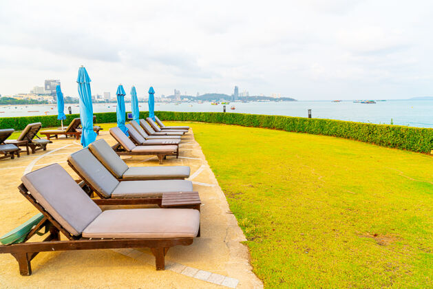 酒店泰国芭堤雅海滩游泳池周围的椅子游泳池或床游泳池和伞周围海滩温泉
