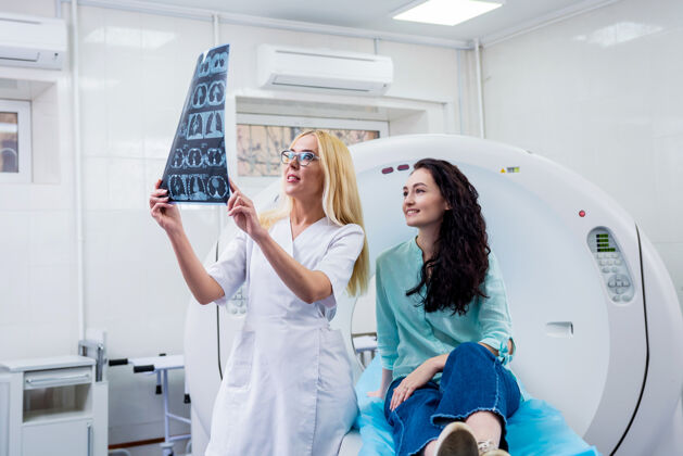 女性放射科医生和一个女病人一起检查ct扫描诊断疾病患者