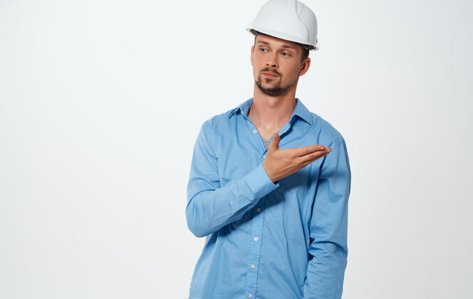 成人在一个孤立的背景下 戴着白色头盔 穿着蓝色衬衫的情感建筑师铅笔建筑人