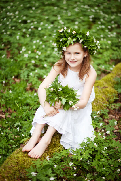 微笑穿着白裙子的漂亮小女孩在春天散步伍德肖像画美丽的小女孩头上戴着春花的花环服饰可爱时尚