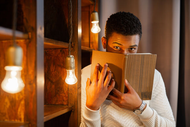 肖像英俊的非洲小伙子在看书家伙非洲阅读