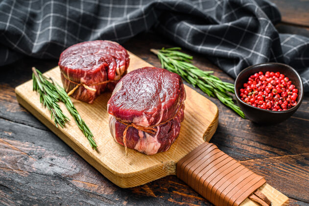 有机生的 新鲜的 大理石花纹的肉排 肉片 肉片板深色木制的背景.top查看生的新鲜牛肉