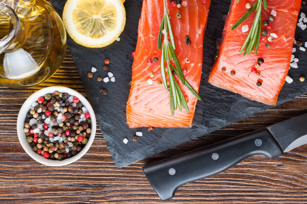 顶视图生三文鱼鱼片和烹饪原料放在木板上 刀放在棕色木桌上海鲜鱼片木材