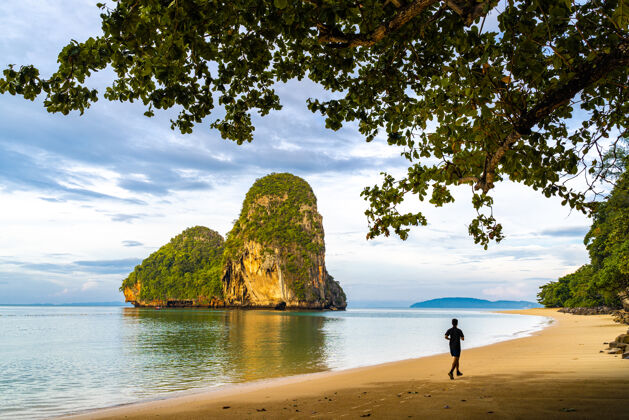 运动一个男人早上在泰国克拉比雷莱的普拉南洞海滩跑步跑步旅行泰国