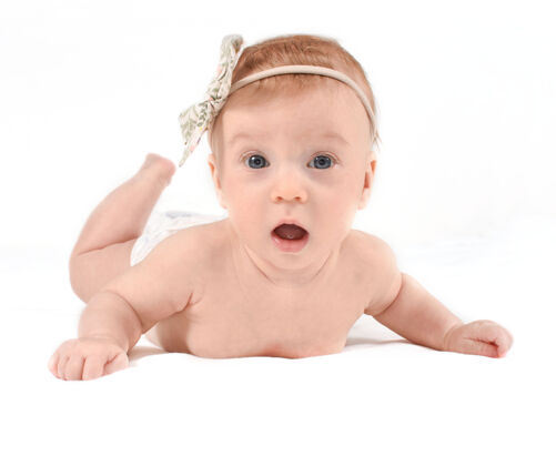 婴儿可爱的 惊奇的 趴着的白人女婴三个月健康神奇