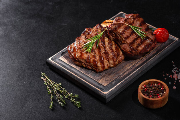 盐新鲜多汁美味黑牛排肉用香料和香草做的菜烤架烹饪木板