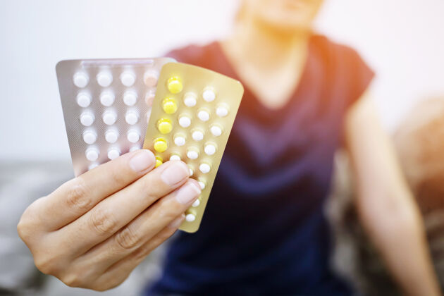 排卵妇女在家里打开避孕药牵手避孕药药剂师妇科健康