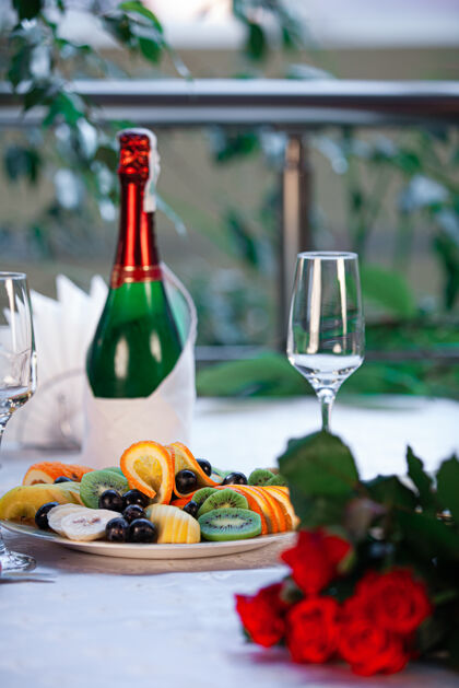 食物餐厅的餐桌上有香槟 小吃和红玫瑰 是浪漫约会的好去处积极小吃晚餐