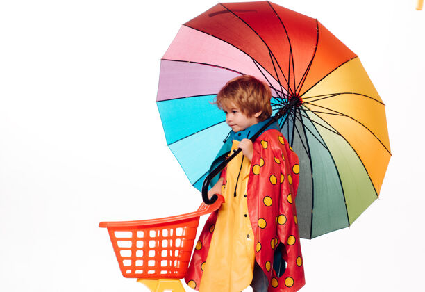 微笑穿着五颜六色雨衣的快乐男孩雨伞.云下雨雨伞可爱穿秋装的小男孩天气秋天肖像