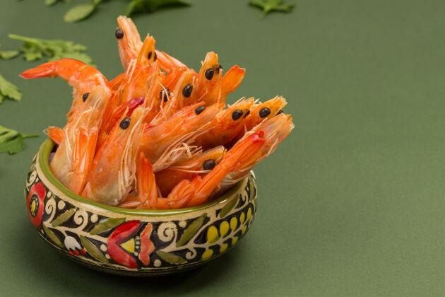 美味有图案的绿碗煮虾小吃大蒜可食用