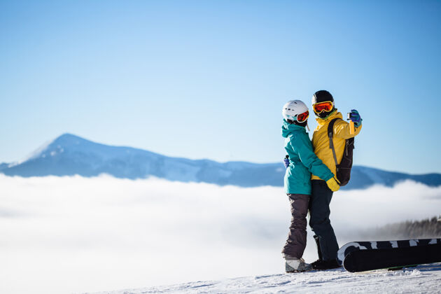 装备滑雪者在山上用智能手机拍照冒险男人风景
