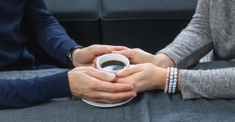 日期一男一女端着一杯咖啡坐在桌边爱男性咖啡