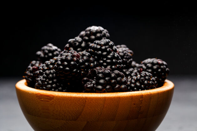植物照片中的黑莓在木杯在空的黑色背景在工作室甜点黑莓浆果