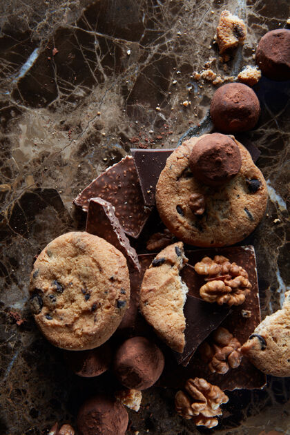 卡路里新鲜的巧克力饼干和巧克力糖果在黑色大理石表面诱惑巧克力剁