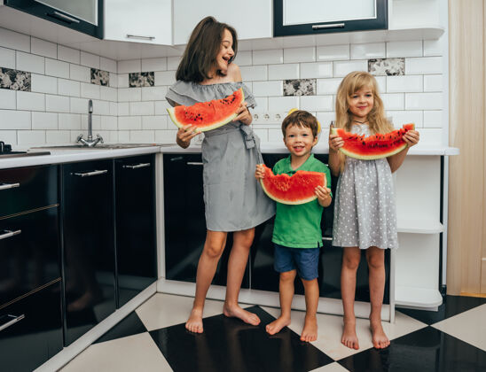 饮食三个快乐微笑的孩子在厨房里吃西瓜可爱食物水果