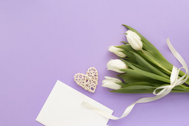 卡片一束白郁金香 紫罗兰色的信封和心形紫色花郁金香