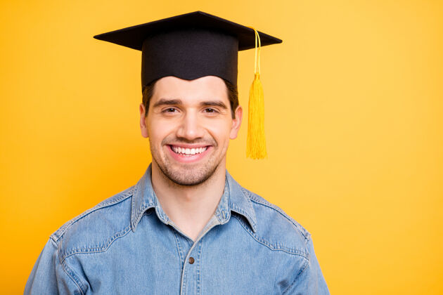 积极图为开朗积极向上的男子从大学毕业后受到启发 实现自己未来人生目标的隔离生动的彩色墙毕业帽子年轻