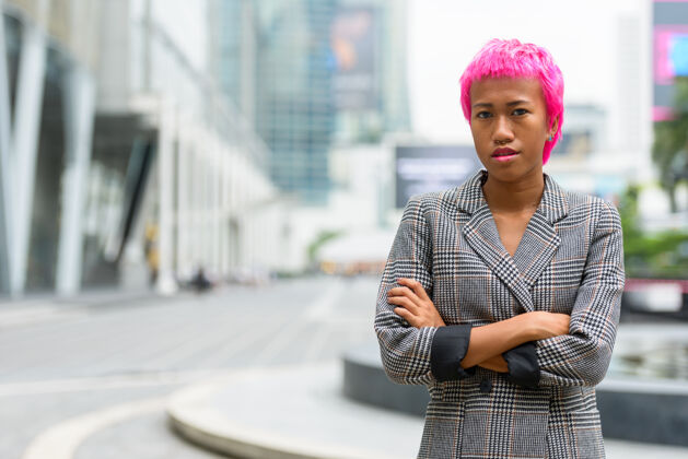 城市景观年轻叛逆的亚洲女商人的画像 粉红色的头发 在城市街道户外个人头发企业