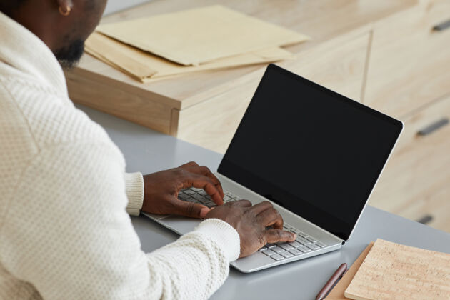 休闲服商人在笔记本电脑上打字的特写镜头他在桌子旁做他的在线工作成人商务计算机