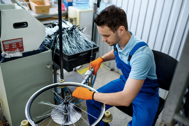 专业工人用机床安装新的自行车辐条工厂自行车车轮装配车间 自行车配件安装工厂服务车间
