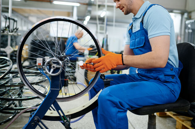 铝机床上的男工人正在检查自行车的轮辋工厂自行车车轮装配车间 自行车配件安装人工作辐条