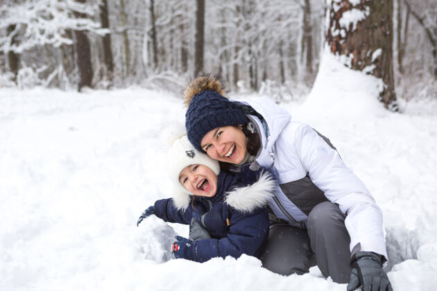 娱乐妈妈和女儿玩雪地游戏 建堡垒 做游戏雪球冬天假期寒冷积极快乐
