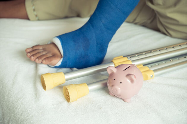 矫形一个有男人腿的存钱罐在手术后用拐杖走路恢复受伤的骨头治疗成人支持