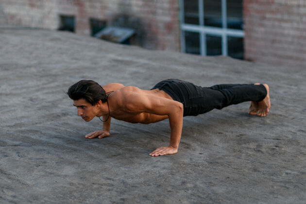 锻炼年轻肌肉帅哥赤裸上身做俯卧撑 晚上上旧屋顶强壮户外训练