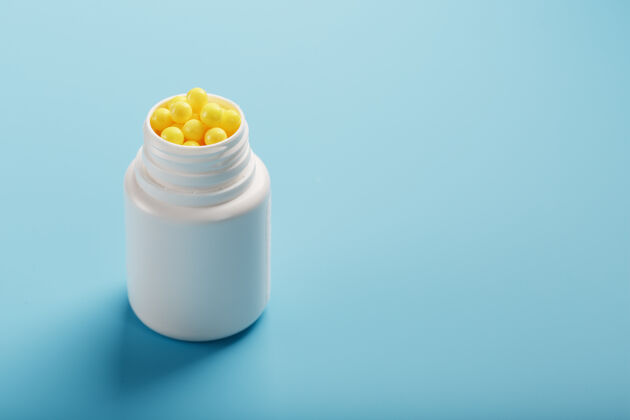 片剂黄色维生素 呈圆形 装在蓝色的白色罐子里背景.健康概念 膳食补充 维生素c免费空间剂量治疗营养