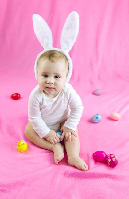 可爱穿得像兔子的宝宝 带着复活节彩蛋过复活节有趣鸡蛋兔子