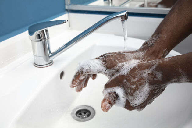 泡沫男士在浴室内仔细洗手 近距离防止感染手湿非洲裔美国人
