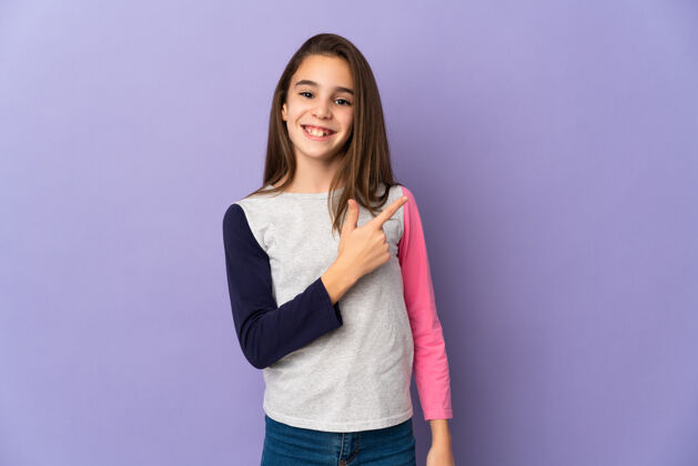 微笑小女孩孤零零地站在紫色的墙上 指着旁边的产品赠送壁板自然点