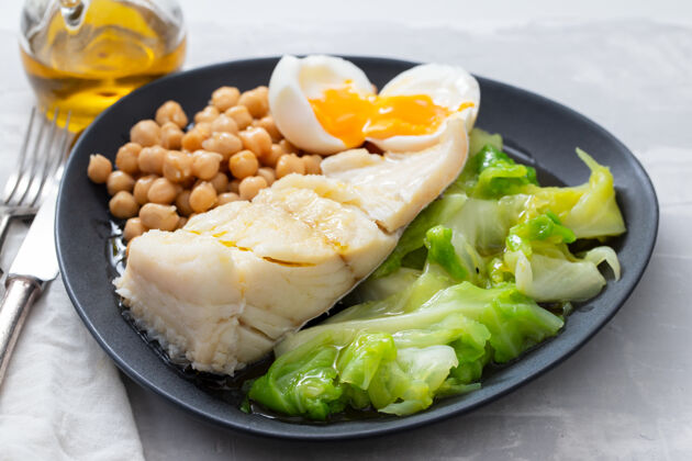 膳食炸鳕鱼配鹰嘴豆 煮鸡蛋和卷心菜橄榄传统混合物